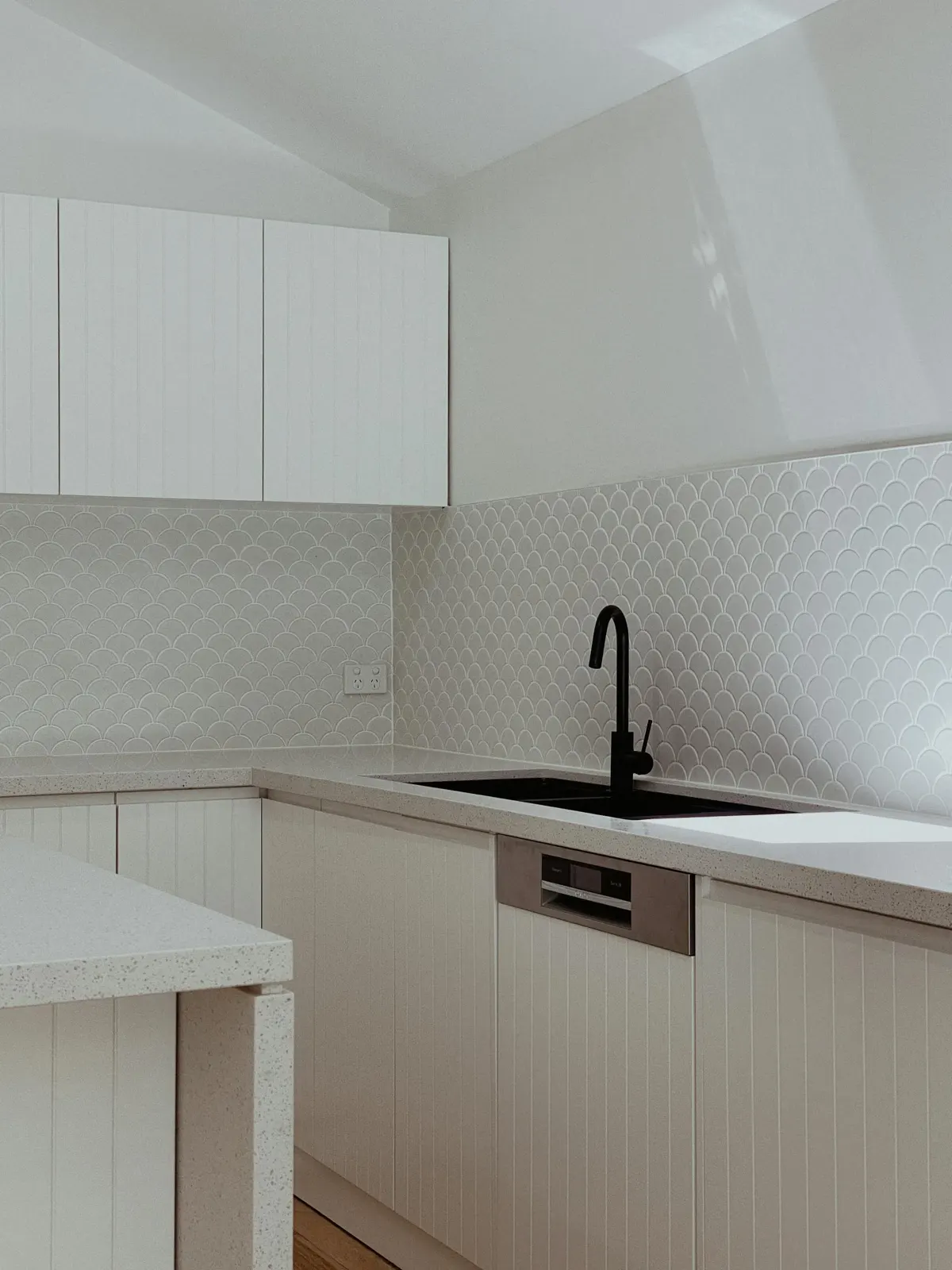 Strakke witte keuken met scallop-tegels