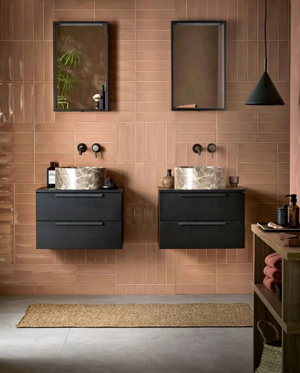 Dubbele wastafel met terracotta tegels en zwevende meubels.